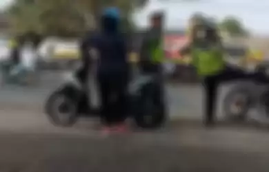 Seorang petugas polisi menendang motor pengendara yang coba kabur