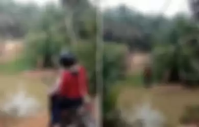 Viral video pengendara motor sebrangi sungai dengan menggunakan tali layaknya tengah bermain flying fox.