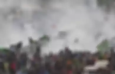 Gas Air Mataditengah masa yang mencoba memanjat pagar DPR