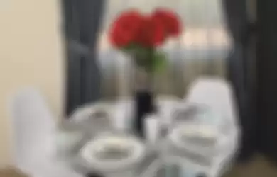 Segar di Area Ruang Makan Pada area ruang makan yang bisa jadi hanya didominasi oleh furnitur, baik meja ataupun kursi yang berwarna netral, akan menjadi sangat diperlukan adanya warna-warna kontras untuk menghidupkan suasana. Kesan pucat pun dapat hilang dari pandangan.  Bisa saja Anda menambahkan taplak meja atau segala benda yang menurut Anda dapat mengisi area meja makan agar tampil cantik. Namun, ada cara yang lebih simpel, yaitu dengan menambahkan bunga berwarna merah di tengah-tengah meja makan. Cukup dengan menambahkan bunga berwarna merah, suasana area meja makan pun langsung menjadi lebih “hidup”.