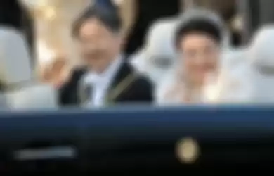 Kaisar Jepang Naruhito dan Permaisuri Masako melambaikan tangan kepada warga yang menyambutnya selama parade penobatannya di Tokyo, Jepang, Minggu (10/11/2019).