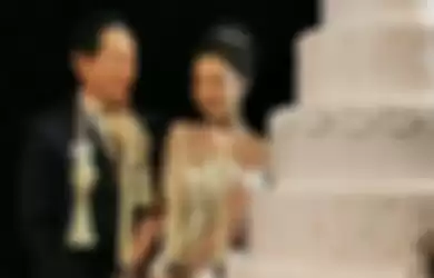 Mempelai pengantin memotong kue pernikahan yang besar