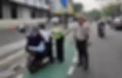 Polisi tindak pelanggar marka jalur sepeda.