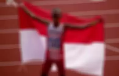 Pelari Indonesia Agus Prayogo mengibarkan bendera Merah Putih seusai memasuki garis finish nomor marathon putra SEA Games 2019 di Stadion Atletik New Clark City, Clark, Filipina, Jumat (6/12/2019). Agus berhasil menyumbangkan medali emas pertama cabang atletik setelah menyelesaikan lomba sepanjang 4