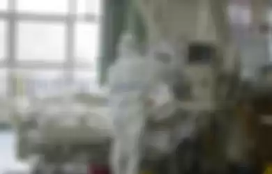  Seorang petugas medis berjas hazmat terlihat sedang memeriksa perangkat medis di dalam unit perawatan intensif rumah sakit