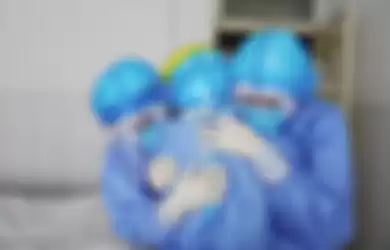 Petugas kesehatan di ruang isolasi di sebuah rumah sakit di Zhouping, Tiongkok, berpelukan untuk saling memberi kekuatan dalam menangani pasien COVID-19. 