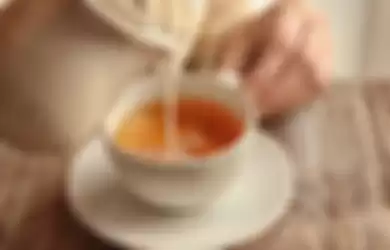 Menuangkan susu ke dalam teh