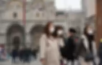 Turis yang mengenakan masker melindungi dari paparan virus corona mengunjungi Piazza San Marco, di Venesia, Italia, 24 Februari 2020. 