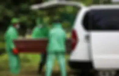 Petugas pemakaman mengeluarkan peti jenazah pasien suspect virus corona atau Covid-19 dari mobil ambulans di TPU Tegal Alur, Jakarta Barat, Kamis (26/3/2020).