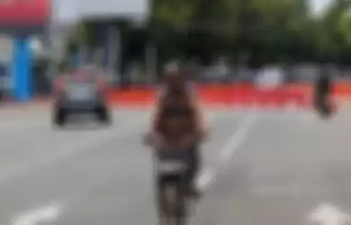 Seorang warga bersepeda melintasi jalan protokol Kota Tegal yang sudah dibatasi dengan ditutup water barrier, Sabtu (28/3/2020)