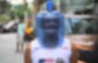 Seorang pria menggunakan galon plastik sebagai pelindung wajah dalam upaya mencegah penularan virus corona (Covid-19) di Manila, Filipina, Minggu (5/4/2020).