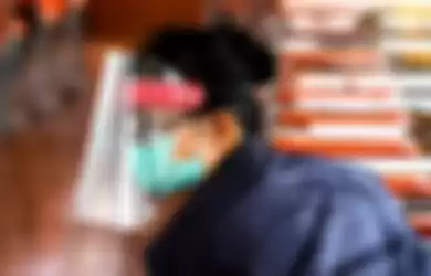 Seorang penumpang mengenakan alat pelindung wajah sebagai tindakan pencegahan terhadap penyebaran virus corona (Covid-19), di sebuah kapal komuter di Sungai Chao Phraya, Bangkok, Thailand,  Rabu (1/4/2020).