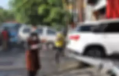 Walikota Surabaya Tri Rismaharini menyemprot disinfektan di jalanan, tindakan yang dianggap sia-sia oleh WHO.