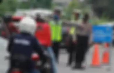 Petugas kepolisian menghalau pengendara motor yang akan masuk ke Jakarta karena tidak mengenakan masker saat penerapan Pembatasan Sosial Berskala Besar (PSBB) di perbatasan Tangerang Selatan dengan DKI Jakarta, Sabtu (11/4/2020). Pada hari kedua pelaksanaan penerapan PSBB masih banyak pengendara yan