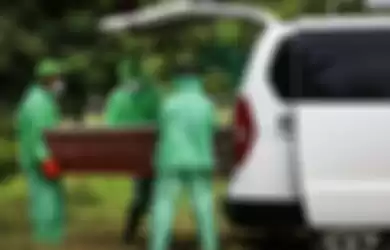 Petugas pemakaman mengeluarkan peti jenazah pasien suspect virus corona atau Covid-19 dari mobil ambulans di TPU Tegal Alur, Jakarta Barat, Kamis (26/3/2020)