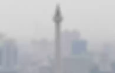 Monas yang tampak berkabut karena polusi udara di Jakarta. Polusi dianggap memperparah penyebaran corona bahkan sebabkan kematian.