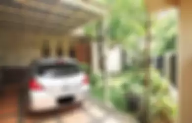 Ilustrasi Cara aman meninggalkan mobil aman di carport, bersebelahan dengan taman.