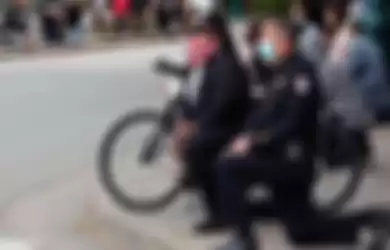 Sebagai bentuk dukungan pada demonstran yang meluas di Amerika Serikat, polisi ikut berlutut.