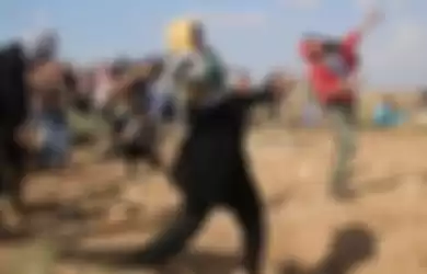 Perempuan Palestina bersama warga melempar batu ke arah tentara Israel dalam bentrokan yang terjadi di Jalur Gaza, 9 Oktober 2015