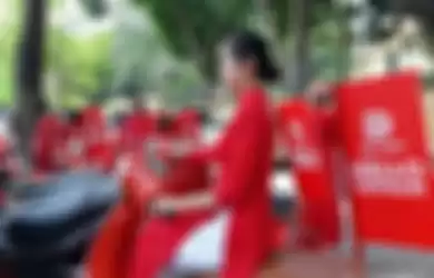 Seorang wanita memakai baju tradisional Vietnam saat mengenalkan Go Viet, perusahaan Gojek yang beroperasi di Vietnam (12/9/2018). REUTERS/Khanh Vu