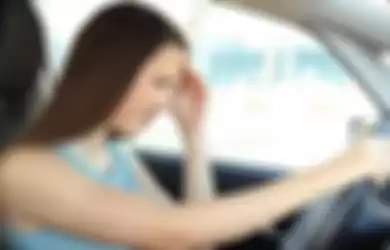 Side view portrait of a driver suffering migraine driving a car