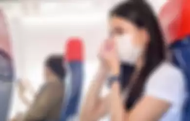 Ilustrasi penumpang pesawat memakai masker selama penerbangan. 