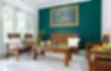 Ruang tamu yang serba putih bersih ini diberi aksen yang kuat, yakni satu sisi dindingnya dicat warna hijau terang.