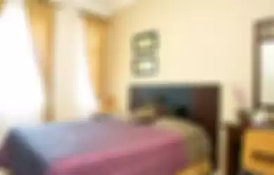 Di kamar tidur anak ini, warna ungu tua muncul sebagai aksen yang berpadu manis dengan warna coklat susu pada dinding. Meja rias dan lemari baju yang digunakan masih berciri perabot jadul ala rumah pecinan tempo doeloe.