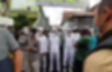 Sejumlah orang berpakain putih menghalang-halangi polisi yang hendak menyampaikan surat pemanggilan kepada Rizieq Shihab di Petamburan, Minggu (29/11/2020) sore. 