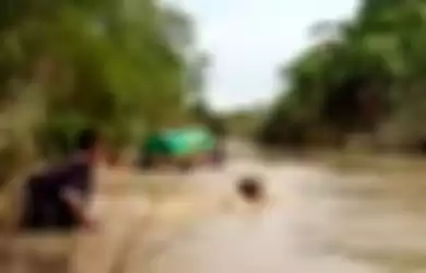 Video yang menunjukkan warga menuju TPU Dusun Gorekanlor, dengan cara menghanyutkan keranda mayat, lantaran debit air sungai sedang tinggi.(tangkapan layar video)