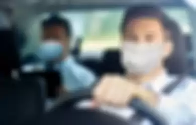 Ilustrasi memakai masker di dalam mobil. Ahli ingatkan meski di dalam mobil yang tertutup, masker lebih baik tetap dikenakan. 