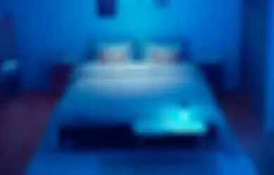 Pemakaian lampu meja disinfeksi UV-C di kamar tidur.