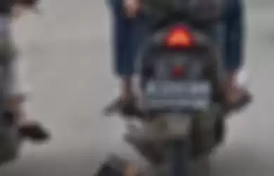 Dua pria bermotor menyeret seekor anjing ketika difoto seorang pengendara motor