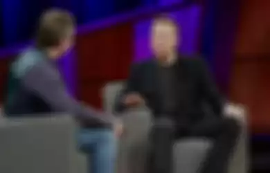 Elon Musk yang memakai pakaian hitam sedang diwawancara oleh seseorang