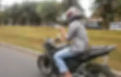 Ilustrasi naik motor sambil main hape