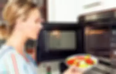 Ilustrasi penggunaan microwave di dapur.