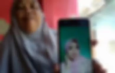 Ibu korban menunjukkan foto anaknya yang dibunuh menantu sendiri.