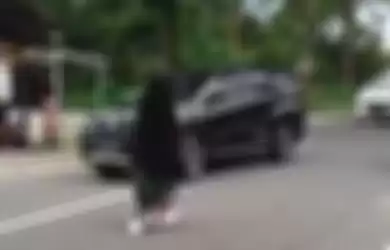 Wanita bercadar terekam kamera video berjalan santai di tengah jalan hingga menimbulkan kemacetan. Polisi ungkap fakta sebenarnya.