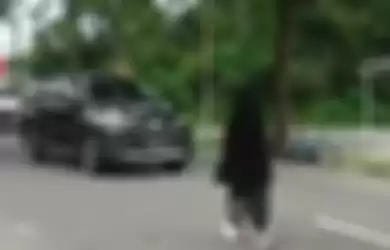 Wanita bercadar terekam kamera video berjalan santai di tengah jalan hingga menimbulkan kemacetan. Polisi ungkap fakta sebenarnya.
