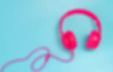 pink headphone isolate on blue background.