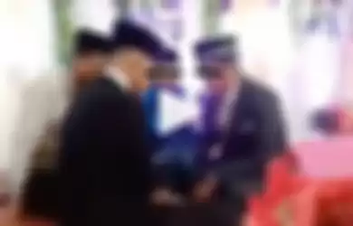 Sebuah video viral memperlihatkan seorang calon ayah mertua yang tiba-tiba menendang calon menantunya di meja akad. Calon ayah mertua mendadak emosi di depan keluarga dan tamu undangan.