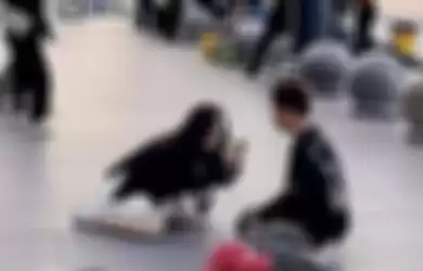 Viral video wanita berlutut di jalan.