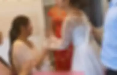 Pengantin wanita menampar wanita hamil yang duduk di ranjangnya karena kesal.