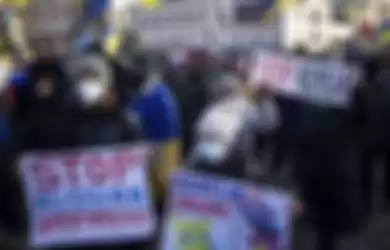 Demonstran dengan bendera dan poster nasional Ukraina berbaris di pusat Kharkiv, kota terbesar kedua di Ukraina, Sabtu, 5 Februari 2022.