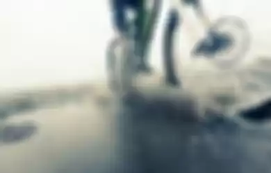 Ilustrasi bersepeda di jalanan yang basah