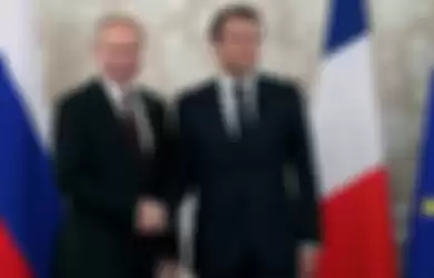 Presiden Rusia Vladimir Putin dan Emmanuel Macron berjabat tangan di pertemuan G20 pada 2019.
