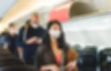 Para penumpang pesawat diimbau untuk tetap pakai masker saat berada di dalam pesawat.