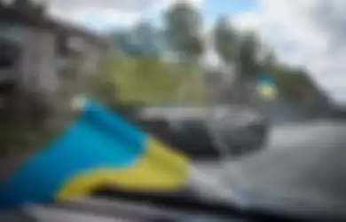 Pasukan Rusia mengendarai kendaraan lapis baja di kota Kupiansk di wilayah Kharkiv