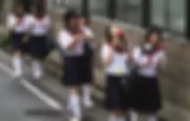 Japanese schoolgirls walking and eating.