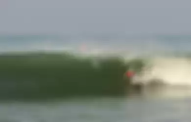 Surfer beraksi di pantai Cimaja, Indonesia 
